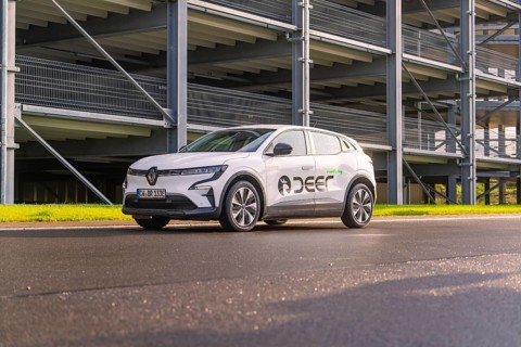 Renault car on an asphalt road in front of a multi-storey car park, Renault Megane, Deer E