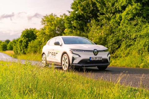 Renault car drives along a green, tree-lined country road, Renault Megane, Deer E Carsharing,