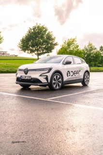 Renault electric car parked in a wet car park under a dramatic evening sky, Renault Megane, Deer E