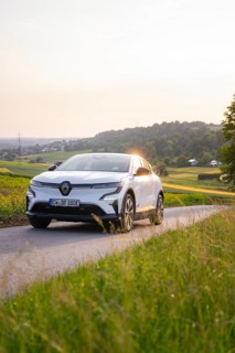 White car driving on a country road in the evening sunshine, Renault Megane, Deer E- Carsharing,