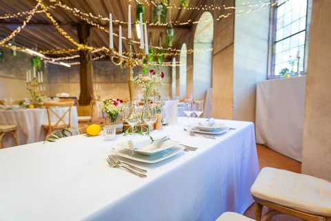 Festively laid table in a room with fairy lights and windows, a warm and inviting atmosphere, event