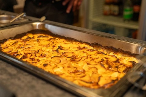 A baked potato casserole in a large tray, baked golden brown, event and wedding location Kloster