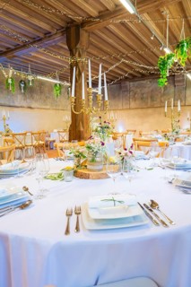 Round table beautifully set with flowers and candlesticks, surrounded by elegant fairy lights