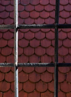 View through bars onto a red shingle roof, house roof, detail, Steyr, Upper Austria, Austria