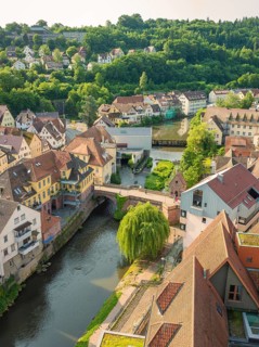 Old town with half-timbered houses along a river, surrounded by green hills, Calw, Black Forest,