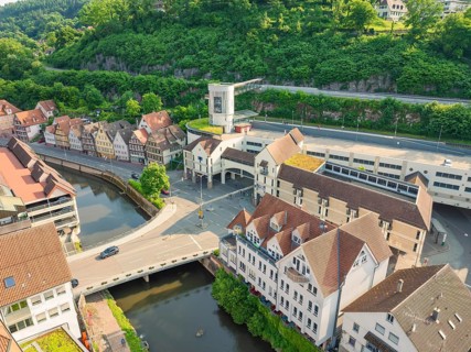 Mixture of modern and historic buildings on a river, surrounded by greenery, Calw, Black Forest,