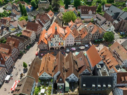 Aerial view of an old town with half-timbered houses and a busy square in an urban environment,
