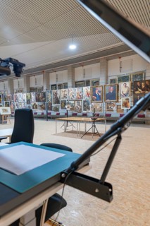 Exhibition gallery with artworks, stands and tables in the interior, historical art exhibition in