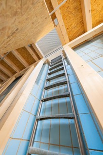 View upwards along a ladder in a room with blue tiles, historical art exhibition in the old