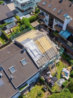 Aerial view of a house with roof under construction in suburban location, roof renovation, house