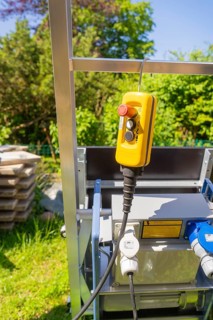 Yellow control unit on a metal frame outdoors in sunny weather, roof renovation, house