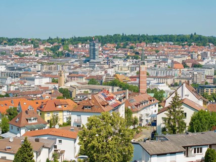 Bird's eye view of a town with various tiled roofs and a church tower, roof renovation, house