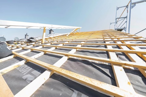Wooden structure of a roof under construction against a clear sky, roof renovation, house