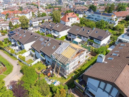 Overview of a city. A house stands in the middle of renovation of the roof in a residential