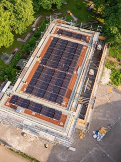 Close-up of a roof with installed solar cells on a construction site with scaffolding in summery
