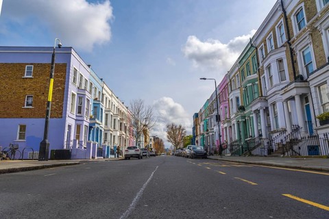 Vibrant pastel colored houses create a picturesque scene along a charming street in notting hill,