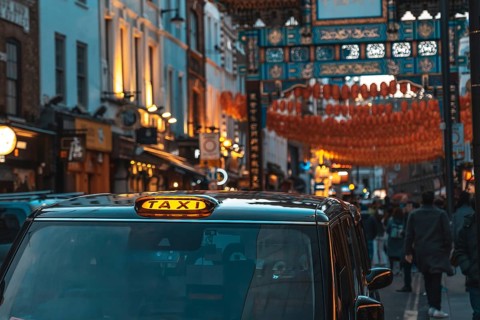 Black taxi cab parked on a london street adorned with chinese lanterns during chinese new year