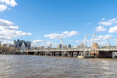 Modern pedestrian golden jubilee bridges flanking the railway hungerford bridge over the river