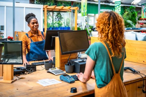 Garden center cashier processing a customer's purchase, creating a positive and efficient shopping