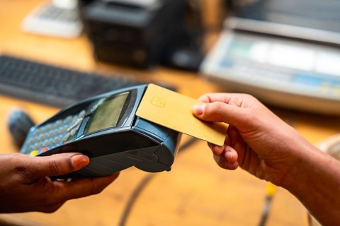 Customer making a purchase using a credit card on a point of sale terminal, highlighting modern