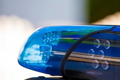 Symbolic image of a police operation: close-up of a flashing blue light on a police car