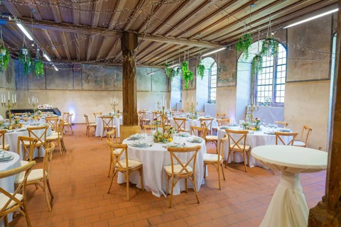Rustic wedding setting with round tables and natural lighting through windows, event and wedding