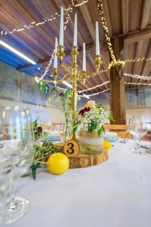 Detailed table decoration with candlestick and licence plate, surrounded by fresh flowers, event