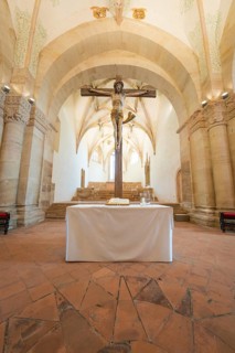 Altar with crucifix in a sacred room with stone arches, event and wedding location Lorch Monastery,