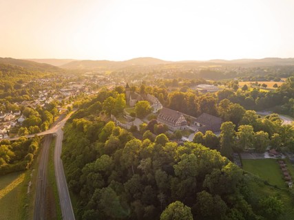 A village on a hill surrounded by forest and half-timbered houses at dusk, event and wedding