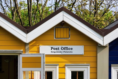Yellow lobster shack, sign with inscription post office, Helgoland philately, facade detail, Museum
