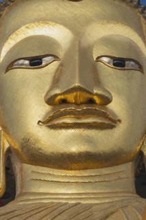Face of a 32 metre high standing Buddha decorated with glass mosaics and 24-carat gold, Luang Pho