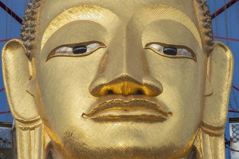 Face of a 32 metre high standing Buddha decorated with glass mosaics and 24-carat gold, Luang Pho