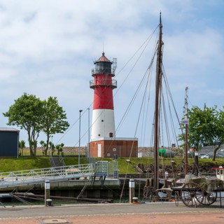 Lighthouse, sailing boat in the foreground, Büsum, North Sea, Schleswig-Holstein, Germany