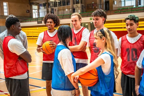 Diverse basketball team engaging in strategic discussions during training sessions in a well lit