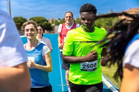 Runners competing fiercely in a race on a vibrant blue track, showcasing their determination and