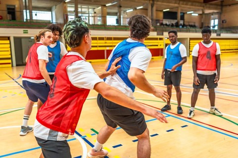 Young basketball players practicing in a gym, focusing on teamwork and skill development during a