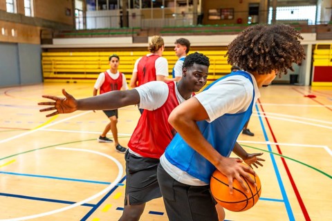 Two basketball players competing for the ball during a training match, showing sportsmanship and