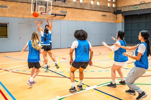 Group of young female athletes competing in a basketball match, showcasing their skills and