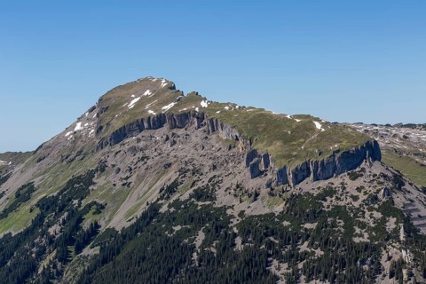 The rocky mountain peak Hohe Ifen and the Gottesacker plateau with snow and grass under a clear