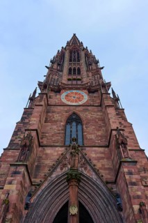 Freiburg Minster, Gothic church tower made of red stone with sculptures and a clock, Freiburg im