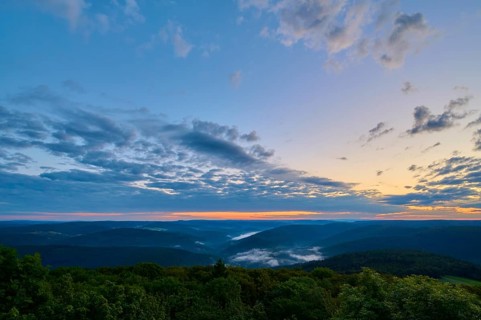 Wide landscape with wooded hills at dawn, peaceful sky with cloud formations, Katzenbuckel,