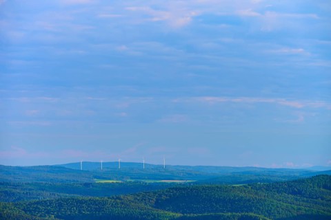 Hilly landscape with clouds, wind turbines on the horizon under a blue sky, Katzenbuckel,