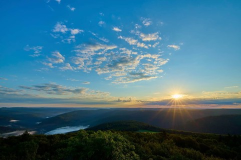 Morning sun over a vast forest landscape, clear sky with some clouds, Katzenbuckel, Waldbrunn,