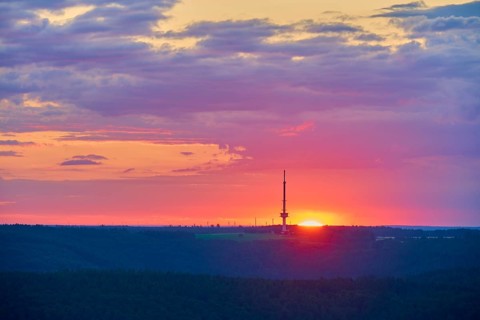 Colourful sunrise with silhouette of a transmitter mast, transmitter Reisenbach, at dusk, seen from