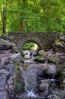 An old, small stone bridge over the Brühlbach, wild and romantic stream and source of the Urach