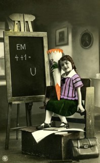 1920 A girl's first day at school, child with a sugar cone in front of a blackboard in a vintage