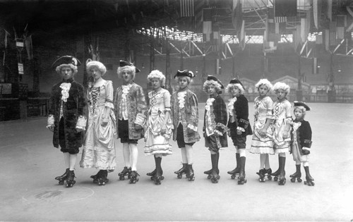 Group in historical costumes on roller skates from big to small, 1920, Group of children in
