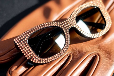 Rhinestone sunglasses resting on leather glove. A symbol of luxury, glamour, and timeless elegance.