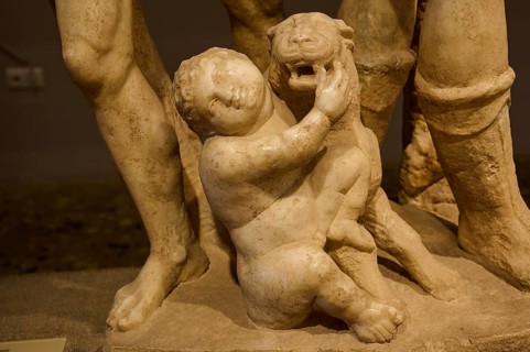 Close-up of an ancient marble sculpture of a child embracing a panther, Panther and Cupid,
