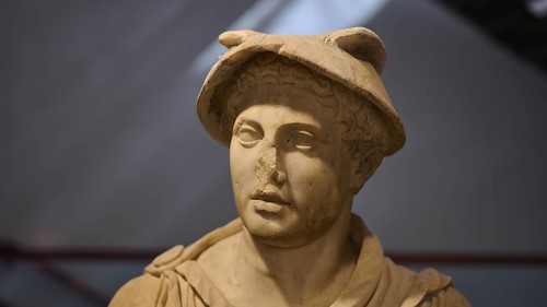 Ancient marble bust of a man wearing a Roman hat, on display in the museum, Hermes, Archaeological